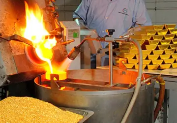 Molten gold being poured into a cast at a refinery