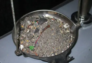 A dish of assorted scrap gold and jewellery ready for testing